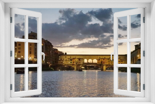 Ponte Vecchio at sunset seen from a boat on the Arno River in Florence, Tuscany, Italy