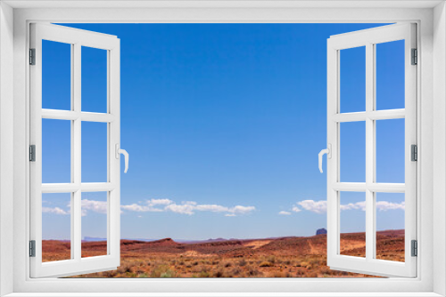 Fototapeta Naklejka Na Ścianę Okno 3D - Low horizon photo of the edge of Monument Valley with red rocks and blue sky