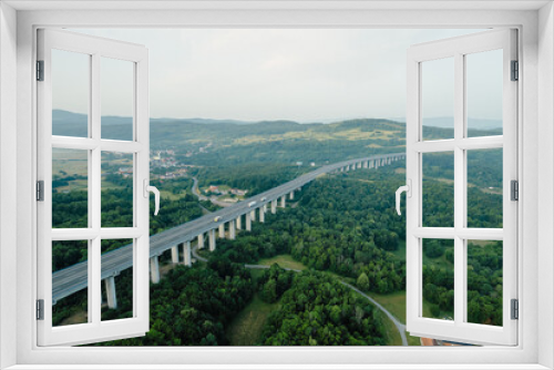 Fototapeta Naklejka Na Ścianę Okno 3D - Transport bridge in mountainous area, road and trees. A panoramic view of nature from above.