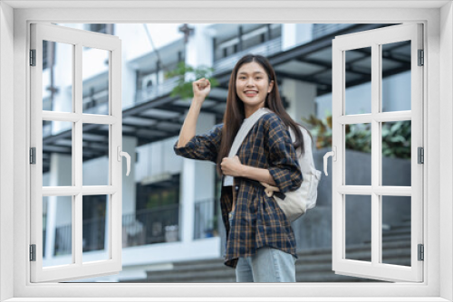 Young Asian female student standing with a beautiful smile carrying a backpack Confidence in preparation for submitting a biological report at university.