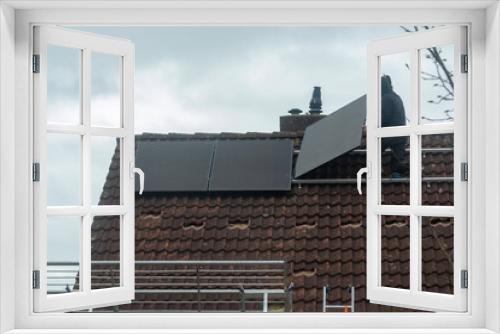 Fototapeta Naklejka Na Ścianę Okno 3D - Installing of solar panels on roof in cloudy winter day, green energy in Europe