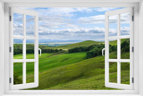 Fototapeta Naklejka Na Ścianę Okno 3D - Idyllic hilly pasture landscape under dramatic skies