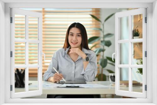 Shot of successful asian female small business entrepreneur sitting at office desk and using digital tablet