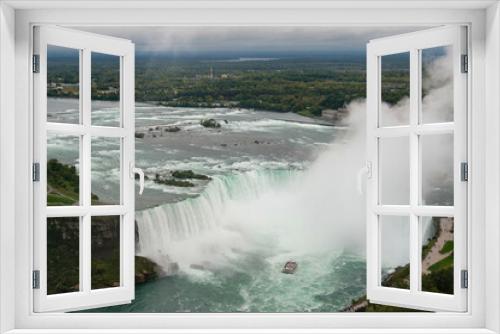 Fototapeta Naklejka Na Ścianę Okno 3D - Panoramic view of Niagara Falls tour boat sailing into the Horseshoe Falls waterfall with water mist drifting upwards towards the sky, Ontario, Canada