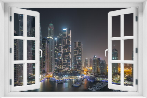 Fototapeta Naklejka Na Ścianę Okno 3D - Dubai marina tallest skyscrapers and yachts in harbor aerial all night timelapse.