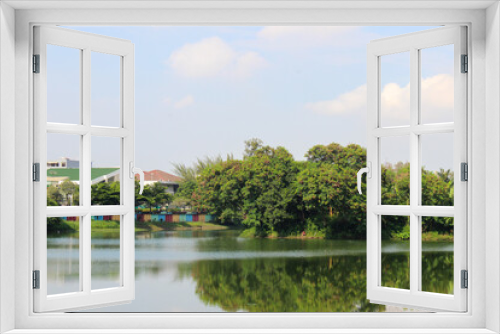 Fototapeta Naklejka Na Ścianę Okno 3D - small island in the middle of sunter lake or danau sunter with bright sky, a small island with trees in the middle of a lake in Jakarta