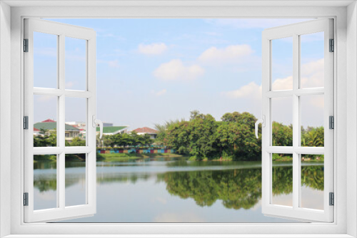 Fototapeta Naklejka Na Ścianę Okno 3D - small island in the middle of sunter lake or danau sunter with bright sky, a small island with trees in the middle of a lake in Jakarta