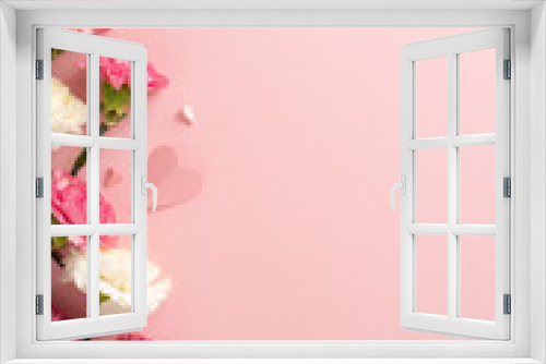 Fototapeta Naklejka Na Ścianę Okno 3D - Mother's Day concept. Top vertical view flat lay of delightful carnation flowers, and pink paper hearts on a soft pastel pink background with copyspace