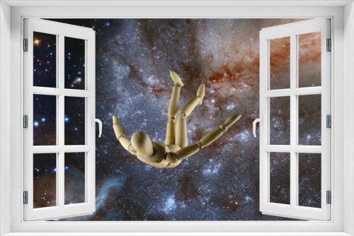 Fototapeta Naklejka Na Ścianę Okno 3D -  wooden mannequin falling in space against the background of a starry space landscape