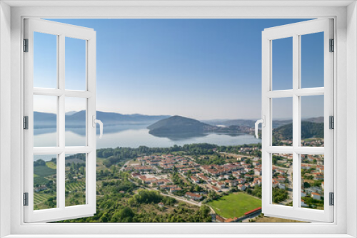 Fototapeta Naklejka Na Ścianę Okno 3D - Landscape of countryside town, village and lake of Orestiada in Kastoria during summer sunny day over a mountain peak in Greece. Aerial, drone, top view. Panorama