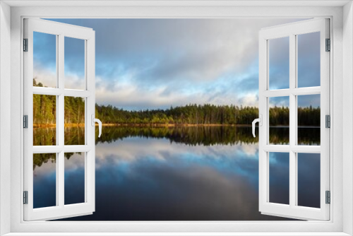 Fototapeta Naklejka Na Ścianę Okno 3D - Scenic view of a tranquil lake surrounded by evergreen trees in Finland