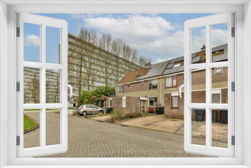 Fototapeta Naklejka Na Ścianę Okno 3D - an empty street in the middle of a residential area with cars parked on both sides and buildings to the side