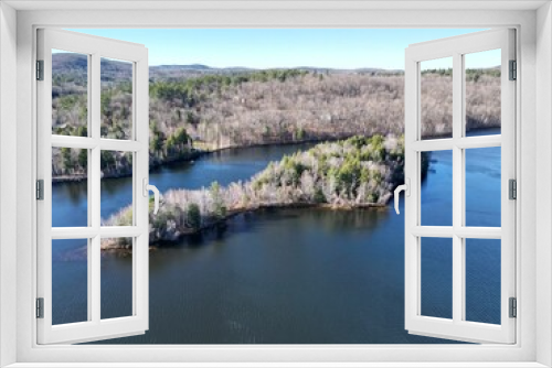 Fototapeta Naklejka Na Ścianę Okno 3D - Areal view of a tranquil lake in New Hampshire, surrounded by lush green trees set in a wooded area
