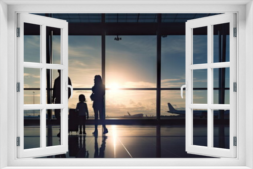 Family travelling with young child walking to departure gate,  silhouette of people, travel concept