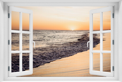 Fototapeta Naklejka Na Ścianę Okno 3D - Sunset in the sea with the waves on the shore breaking on the sand in the summer vacation
