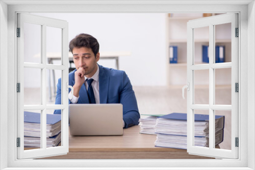 Young male employee and too much work in the office