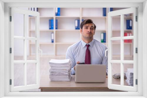 Young male employee and too much work in the office