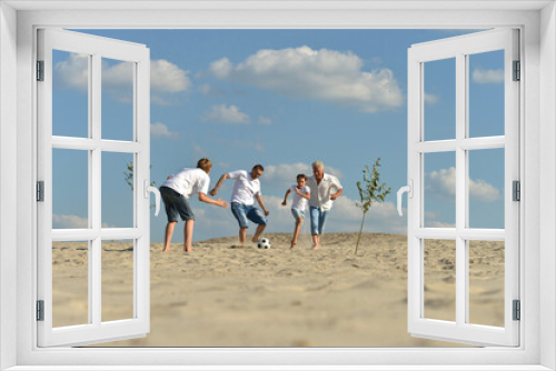 Fototapeta Naklejka Na Ścianę Okno 3D - Family playing football on a beach in summer day