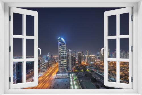 Fototapeta Naklejka Na Ścianę Okno 3D - Dubai's business bay towers aerial night timelapse. Rooftop view of some skyscrapers