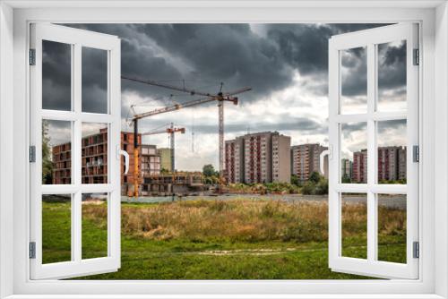 Fototapeta Naklejka Na Ścianę Okno 3D - Industrial crane on construction site under cloudy sky