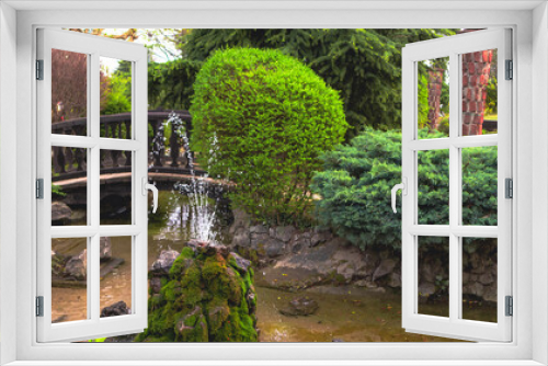 Fototapeta Naklejka Na Ścianę Okno 3D - 
small park with pond and picturesque rock fountain, with bushes and trees in spring 2