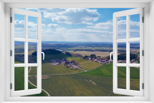 Fototapeta Naklejka Na Ścianę Okno 3D - Green field, farmland with picturesque European landscape. Road in the middle of fields. Soft light. footage video drone view. in the background a range of mountains