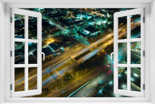 Fototapeta Naklejka Na Ścianę Okno 3D - Aerial view of american freeway intersection at night with fast driving cars and trucks in Tampa, Florida. View from above of USA transportation infrastructure
