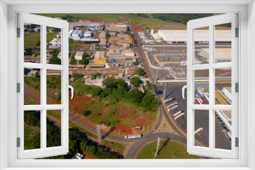 Fototapeta Naklejka Na Ścianę Okno 3D - Aerial image of chemical industry. Large structure of pipelines and warehouses with movement of cargo trucks. Industry surrounded by vast vegetation and trees. Located in Brazil, city of Paulínia.