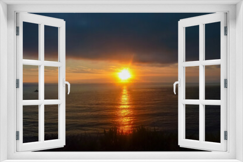 Fototapeta Naklejka Na Ścianę Okno 3D - Watching sunset from Bixby Creek Bridge on coastline of Big Sur, Monterey county, California, USA, America. View of horizon of Pacific Ocean. Sun is reflecting in calm sea. Vibrant clouds in the sky