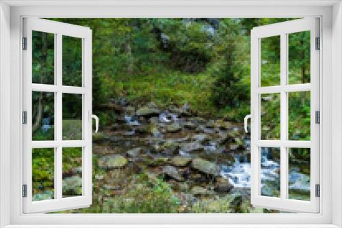 Fototapeta Naklejka Na Ścianę Okno 3D - Beautiful small waterfall full of small and big rocks and stones with green trees around next to mountain trail in Giant mountains