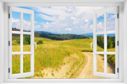 Fototapeta Naklejka Na Ścianę Okno 3D - lane through grassy meadow. green hills rolling in to the distance. blue sky above the distant mountain ridge on the horizon. rural tourism in summer. explore countryside of ukraine