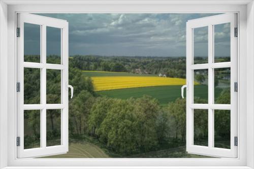 Fototapeta Naklejka Na Ścianę Okno 3D - Pole rzepaku obok wsi i lasu na tle nieba #7