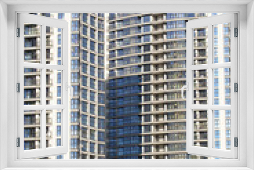 Fototapeta Naklejka Na Ścianę Okno 3D - Modern high-rise buildings made of concrete and glass. Construction site. The final stage of construction. Against the background of the blue sky.