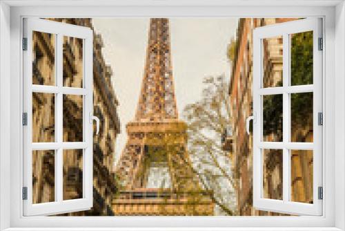 Fototapeta Naklejka Na Ścianę Okno 3D - View of the Eiffel Tower from a nearby street full of residential buildings. Paris, France