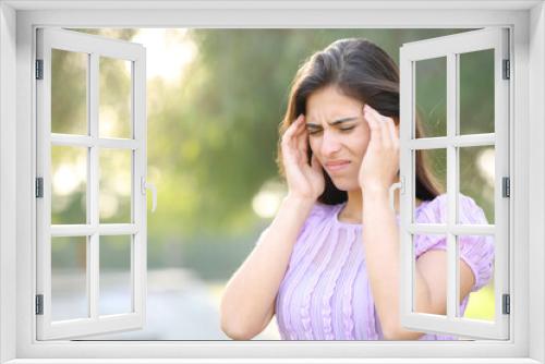 Woman suffering migraine in a park