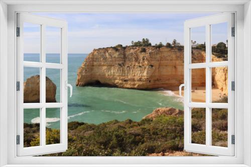 Fototapeta Naklejka Na Ścianę Okno 3D - Limestone rock cliffs and rock in the Atlantic Ocean with a small sandy beach on a sunny winter day along the Seven Hanging Valleys Trail in southern Portugal.