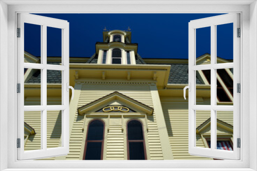 Fototapeta Naklejka Na Ścianę Okno 3D - Looking up at an old Colonial Yellow building against a perfect blue sky on Vinalhaven Island Maine