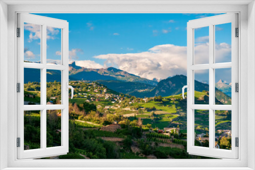 Idyllic Highlands near Sion, Switzerland at sunny summer day. Tranquility of the rolling hills adorned with charming farmhouses and lush vineyards, creating a serene and idyllic scene