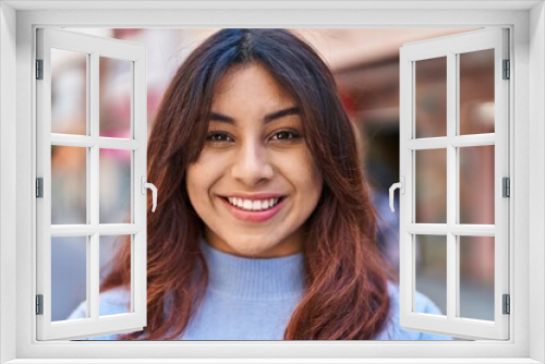 Young hispanic woman smiling confident standing at street