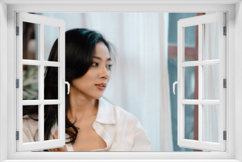 Happy smiling young beautiful Asian woman person in white dress enjoying first morning in her bedroom at home, Comfortable free and relax vacation time lifestyle, rest of lazy day concept.