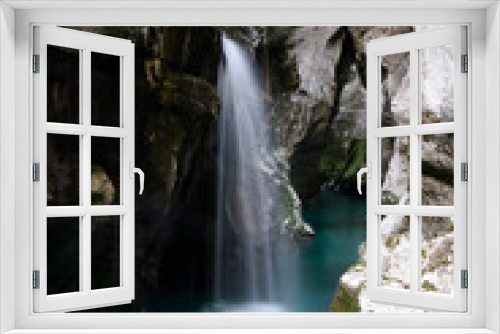 Fototapeta Naklejka Na Ścianę Okno 3D - Blurred image of a beautiful short waterfall in big gorge of the river Soca
