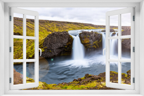 Fototapeta Naklejka Na Ścianę Okno 3D - beautiful waterfall falling in the middle of mountains in iceland with a clear day and a ray of sun