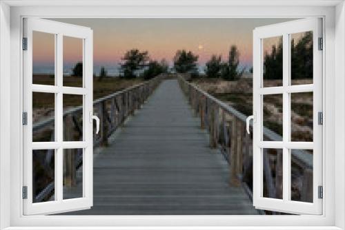 Fototapeta Naklejka Na Ścianę Okno 3D - Wooden walkway leading to the beach at sunset in summer