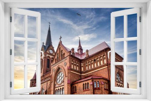 Fototapeta Naklejka Na Ścianę Okno 3D - Cathedral of the Immaculate Virgin Mary in Jelgava city, Latvia under the sunset sky. Birds flying in the sky.