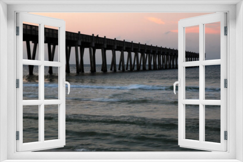 Fototapeta Naklejka Na Ścianę Okno 3D - The Pensacola Pier juts out into the ocean and gulf from the beach during sunrise
