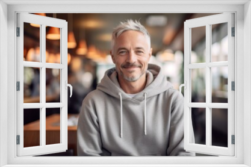 Conceptual portrait photography of a satisfied mature man wearing a stylish hoodie against a bustling cafe background. With generative AI technology