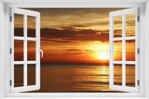 Fototapeta Naklejka Na Ścianę Okno 3D - sun sets behind the horizon, a beautiful sea sunset. view low over the water. Bright red, orange sky over the ocean