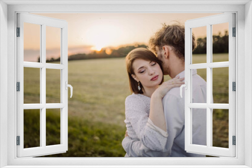 couple in love in a field at sunset on a date in summer. Wedding engagement of a young couple.