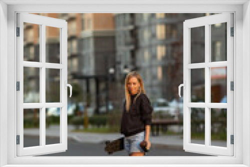 Beautiful Young woman walking with longboard in the afternoon. Skateboarding. Outdoors, lifestyle