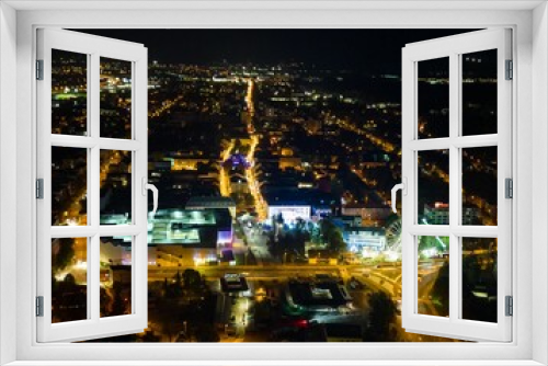 Fototapeta Naklejka Na Ścianę Okno 3D - Aerial view of streets and buildings of a city illuminated at night